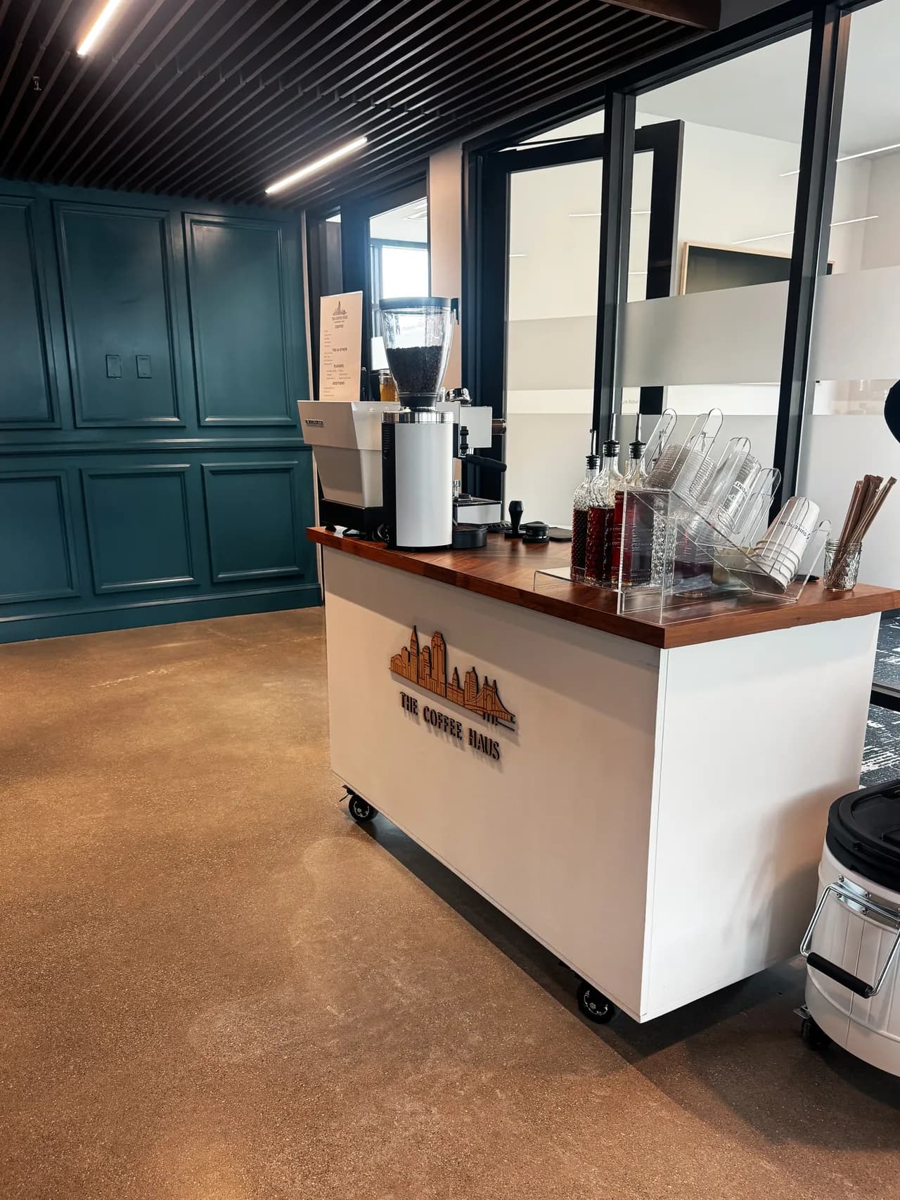 The Coffee Haus coffee cart with its Cincinnati skyline logo set up inside an event venue